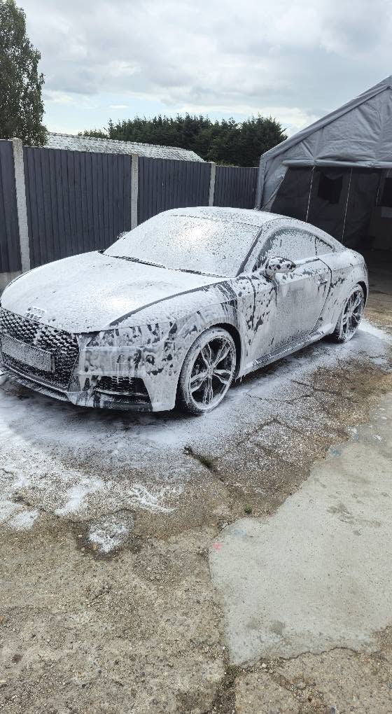 White Audi TT covered in thick snow foam during exterior decontamination