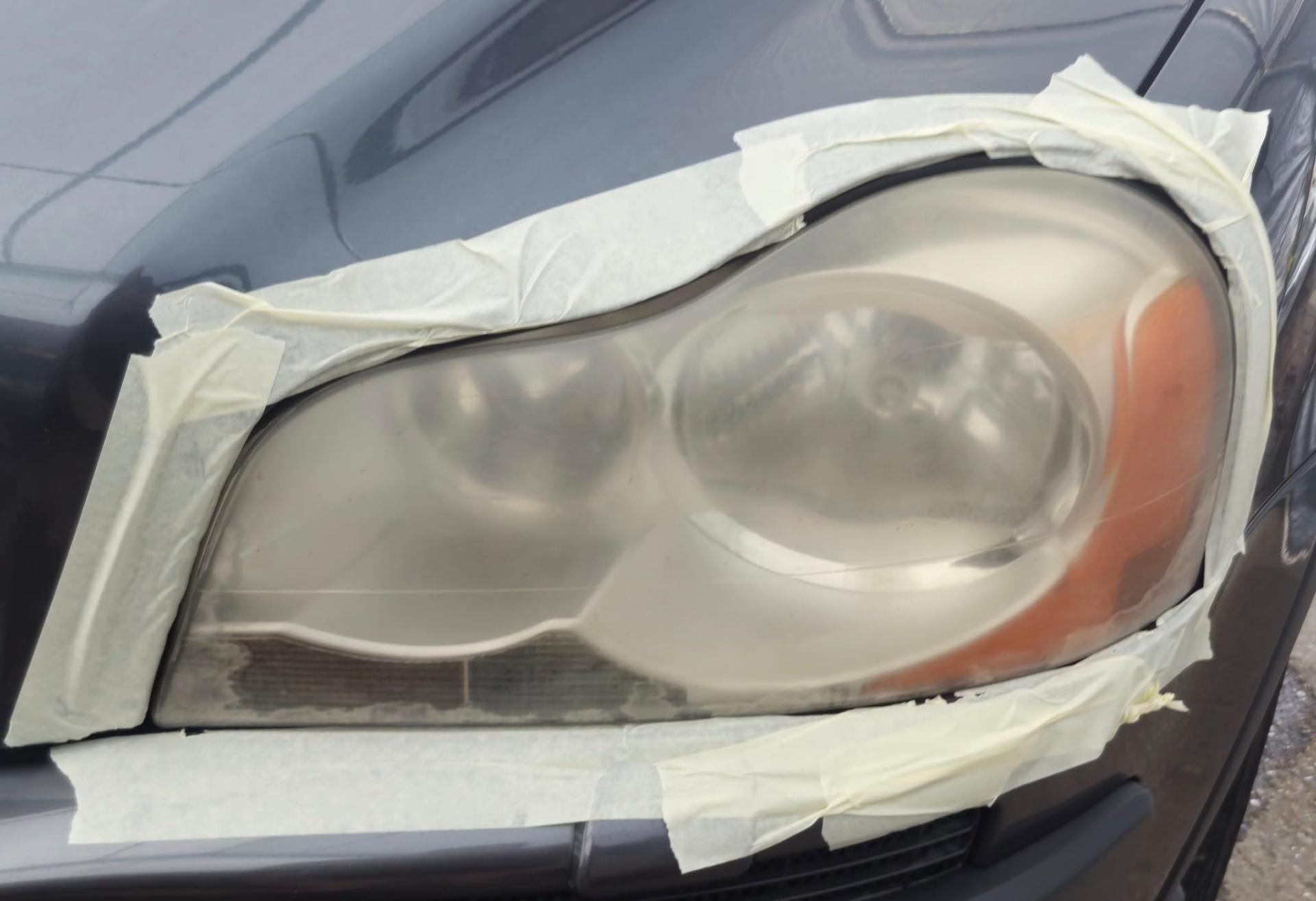 Volvo XC90 headlight masked, showing yellowing before restoration